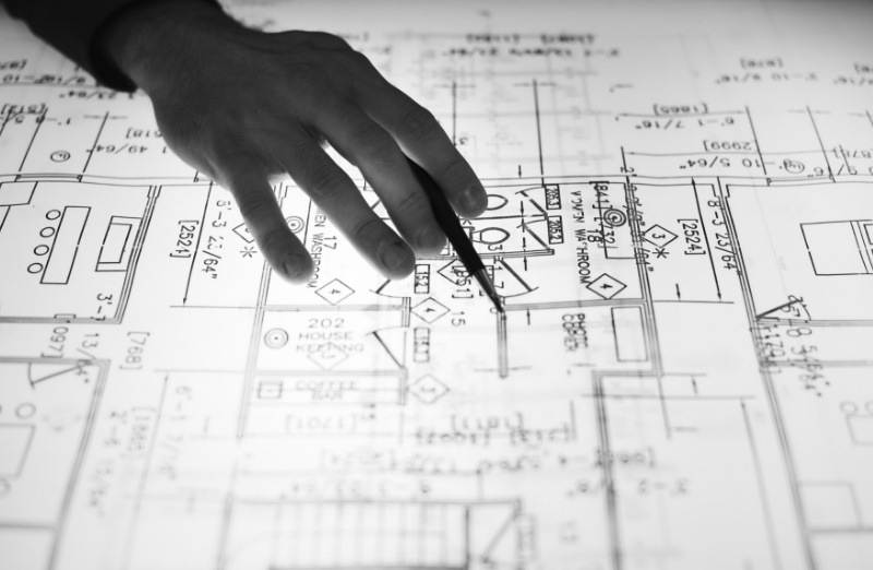 Main sur un plan de chantier
